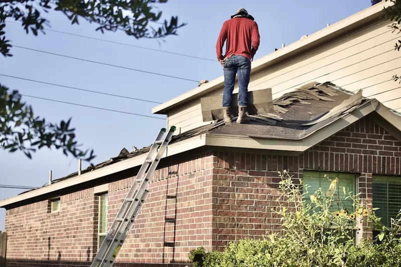 Professional roofer working on a residential roof in Essex Village